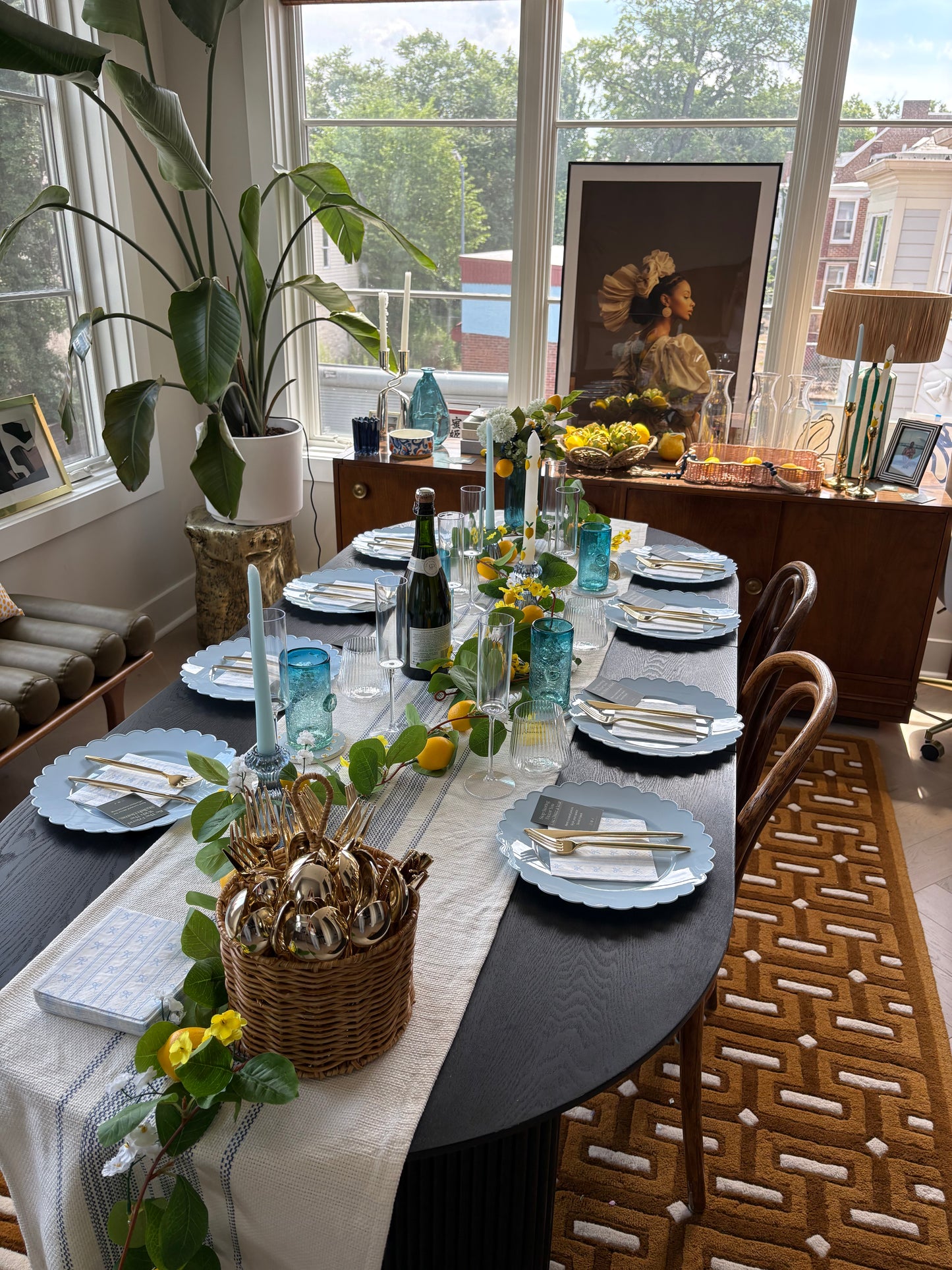 Elegant dining table set for a meal with decorative items and plants in a bright room.